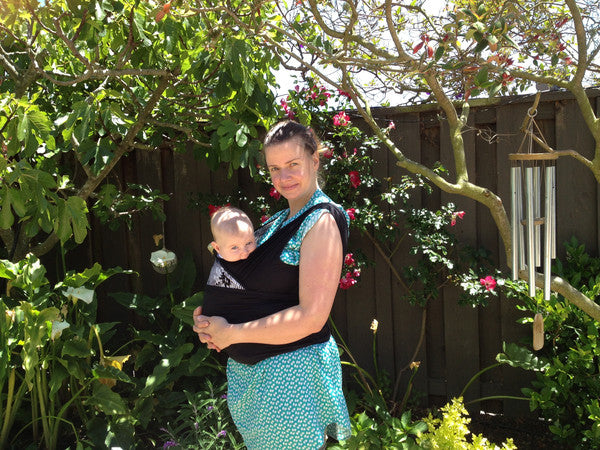 Mother outside with baby in nesting days carrier