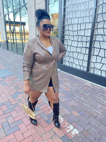 Morgan B. wearing a gold metallic blazer and black over the knee boots with black sunglasses