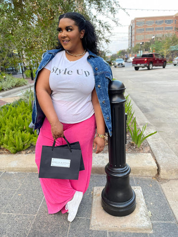 Morgan B. holding shopping bags while wearing a graphic t-shirt and pink overflow pants