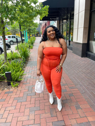 Morgan B. wearing Orange Flaunt It Ruched Set with white cowboy boots and a mini croc skin bucket bag