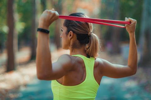 woman using a resistance band for stretching and warm-up