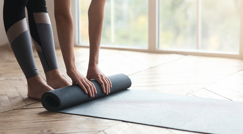 woman uses yoga mat in her home gym