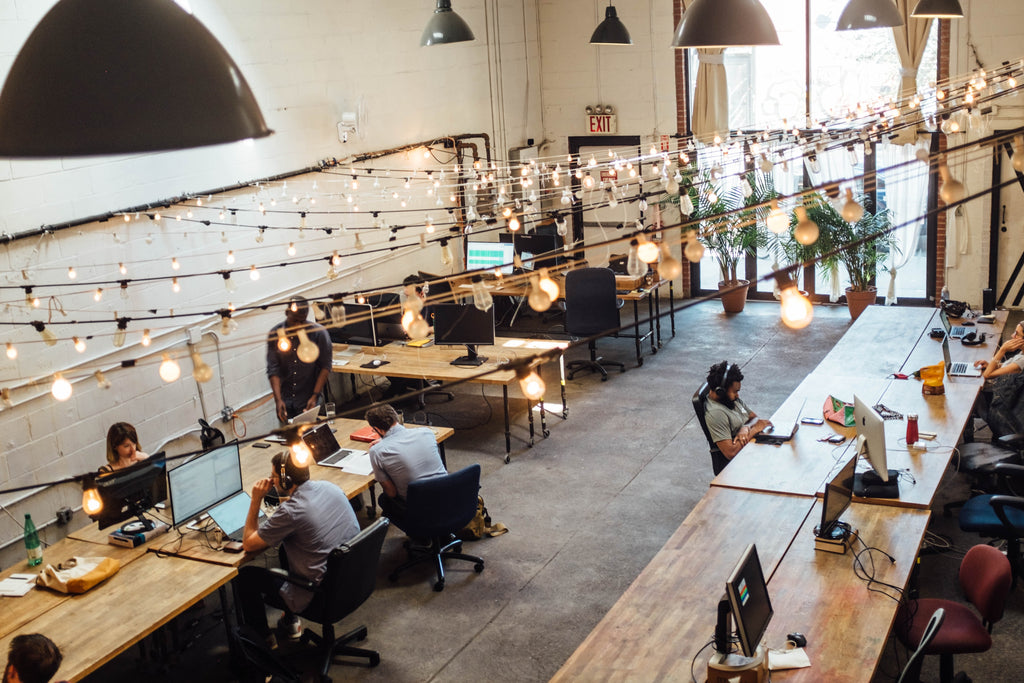 people working with computers in a large industrial space