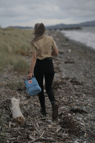 blue kanken bag on beach