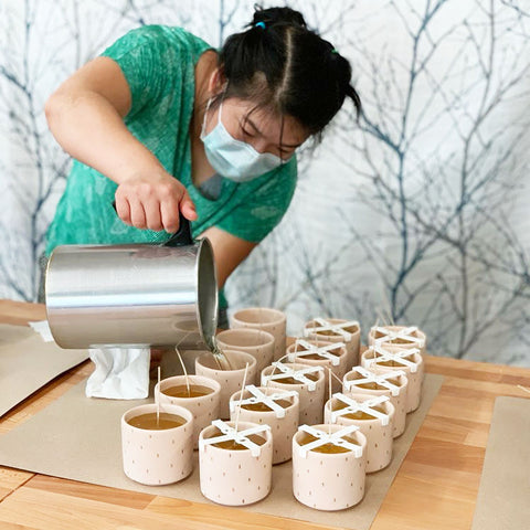 Candle-maker Sai Aye, originally from Burma, pouring soy coconut candles at Prosperity Candle