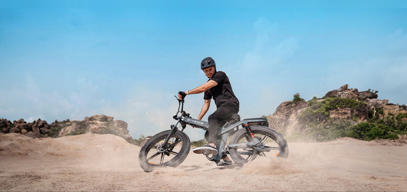 A man riding a fat tire electric bike, engwe x26, on the sand