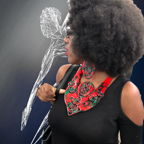 Woman with black top and afro in large statement necklace 