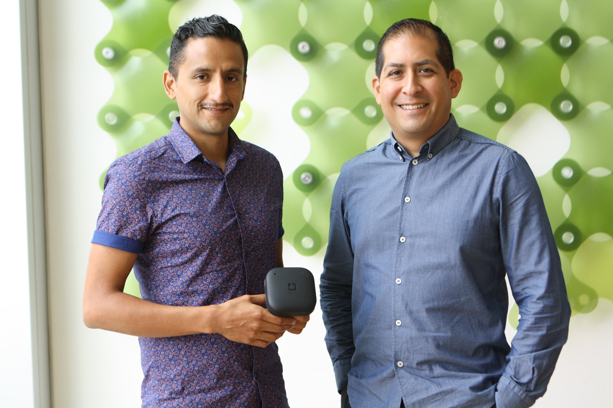 Jorge and Mauricio portrait shot standing in front of green background