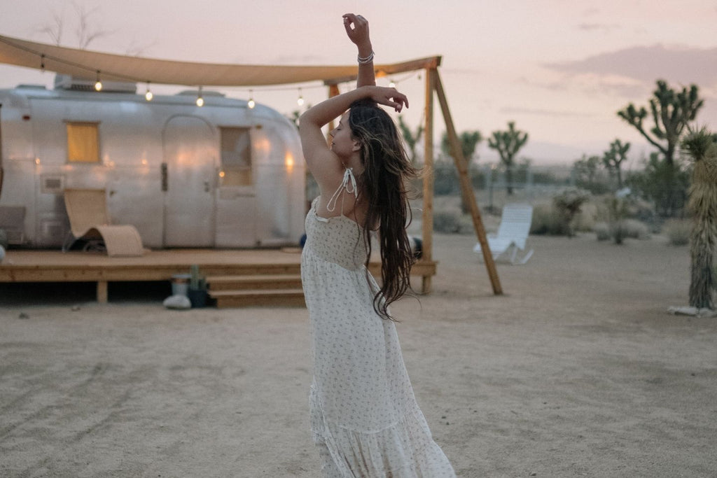 woman dancing in light sun dress to keep summer holiday alove