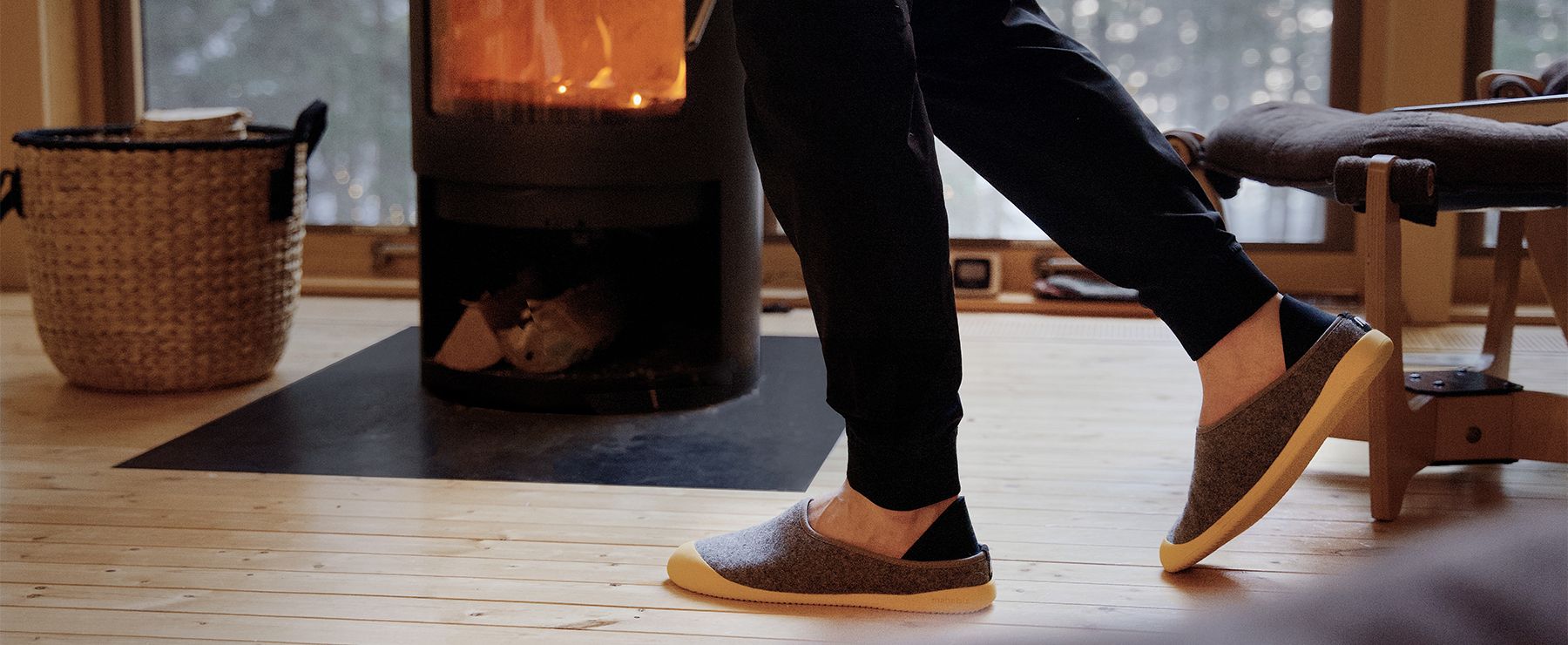 man walking in slippers in front of fire to warm feet