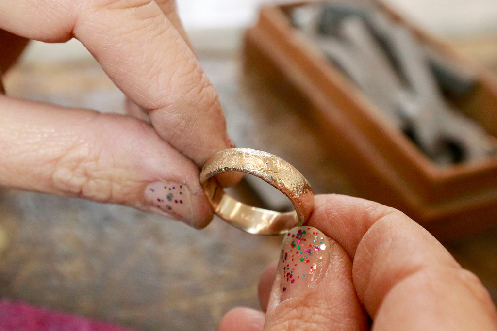 Close-up of Betsy holding ring on jewelry bench