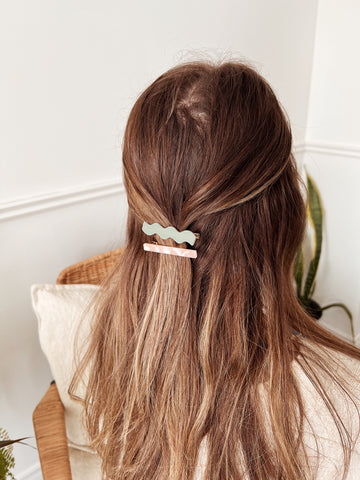 A girl with long brown with a half ponytail and barrettes hair clips Palmeras and Camélia from Mimi & August