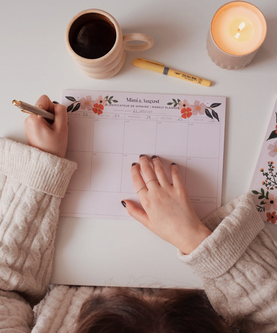 A girl planning her schedule with her Mimi & August weekly planner