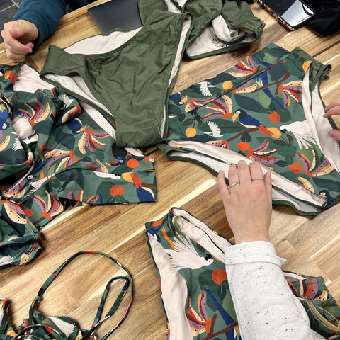 mimi and august swimsuits in a table with tropical patterns