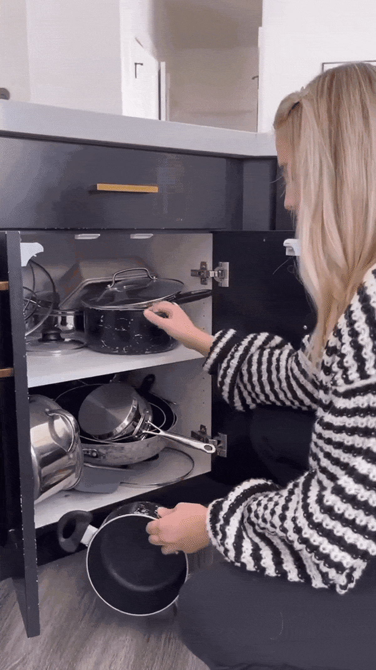 "A woman opened the kitchen cabinets and found a neatly stacked Meyer cookware essential set inside.      "