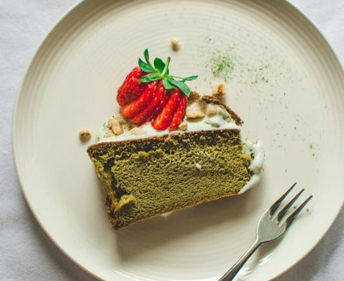 Matcha green tea cake with vanilla yoghurt frosting, topped with strawberry and nuts