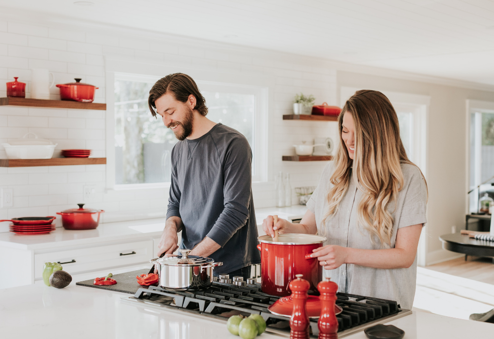 A man and a woman preparing and cooking food