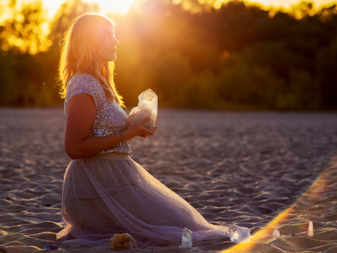 woman holding crystal on the beach using emotional intelligence