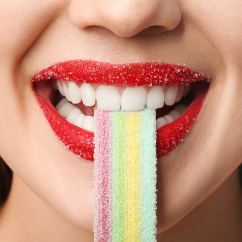 Photo d'une bouche mangeant un bonbon