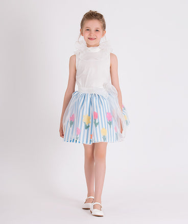 white organza blouse with blue and white striped skirt that has colorful flower prints