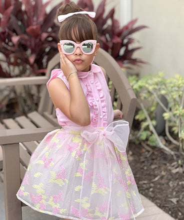 pink ruffled blouse and pastel skirt with a bow