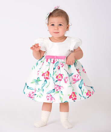 ecru baby dress with pink flower prints and a little bow on the waist