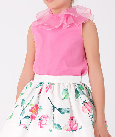 pink blouse with ruffled neckline and ecru floral skirt 