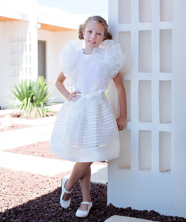 white ruffled blouse and striped skirt with a bow on the waist