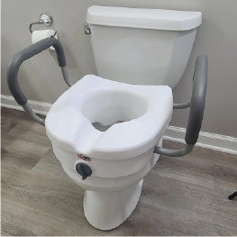 A raised toilet seat with handles on top of a toilet