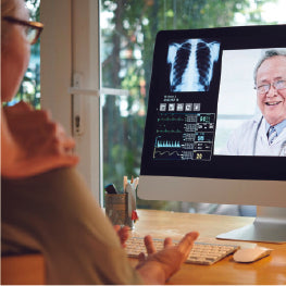 An elderly woman using telehealth on a computer