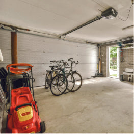 A home garage with bikes and a lawn mower