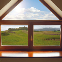 A close-up of a triangular window overlooking a grass field