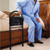 An elderly man getting out of bed using a bed rail