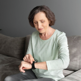 An elderly woman using her smartwatch