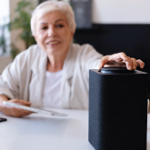 An elderly woman adjusting her virtual assistant