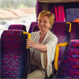 An elderly woman riding a public bus