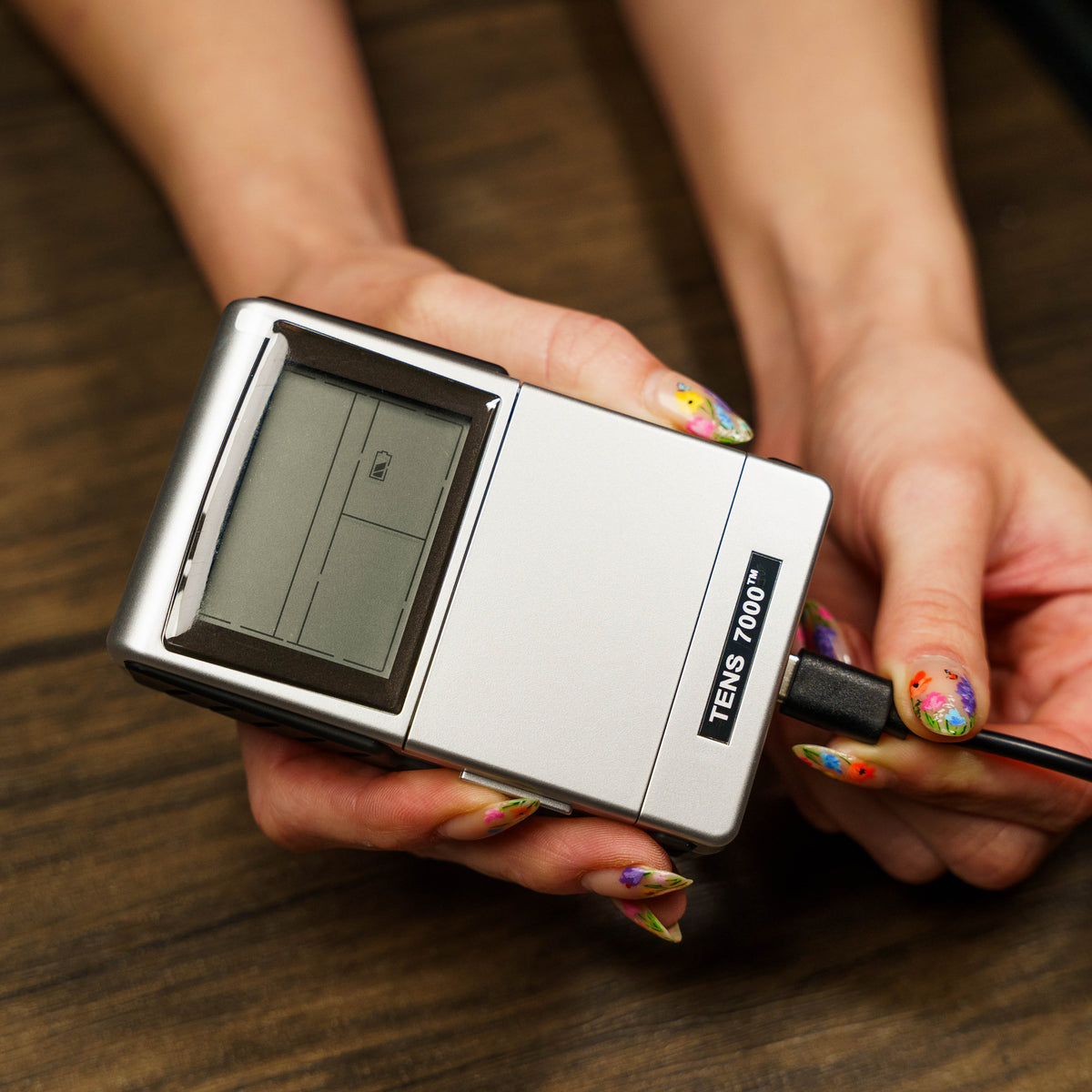 The TENS and EMS combo unit being plugged in to charge