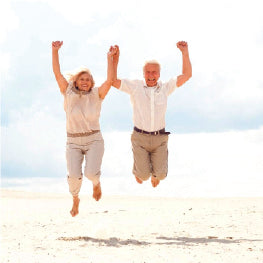 A senior couple jumping on sand