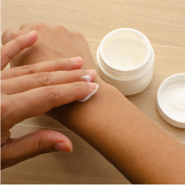 A person putting cream on their wrist