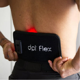 A man placing a red light therapy device on their hip area