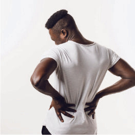A man facing away holding his back in pain