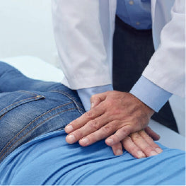A chiropractor pressing down on a patient's hip bursitis