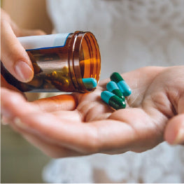 Pain medications being poured into a hand