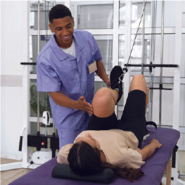 A physical therapist stretching a womans hip