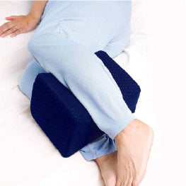 A woman laying down with a knee pillow between her legs