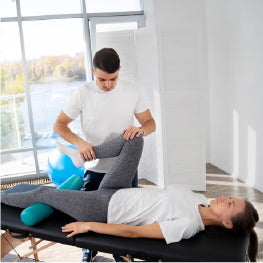 A physical therapist stretching a patient's hip flexor