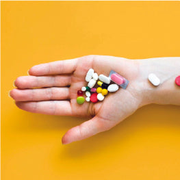 A persons hand with pills on it