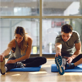 A man and woman stretching their hips