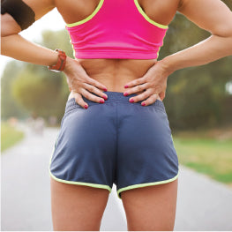 A woman holding her hip in pain from a muscle strain