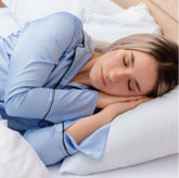 A woman sleeping in bed on her side